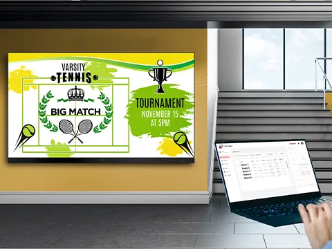 a laptop near a large display in a school hallway annoucing a tennis game